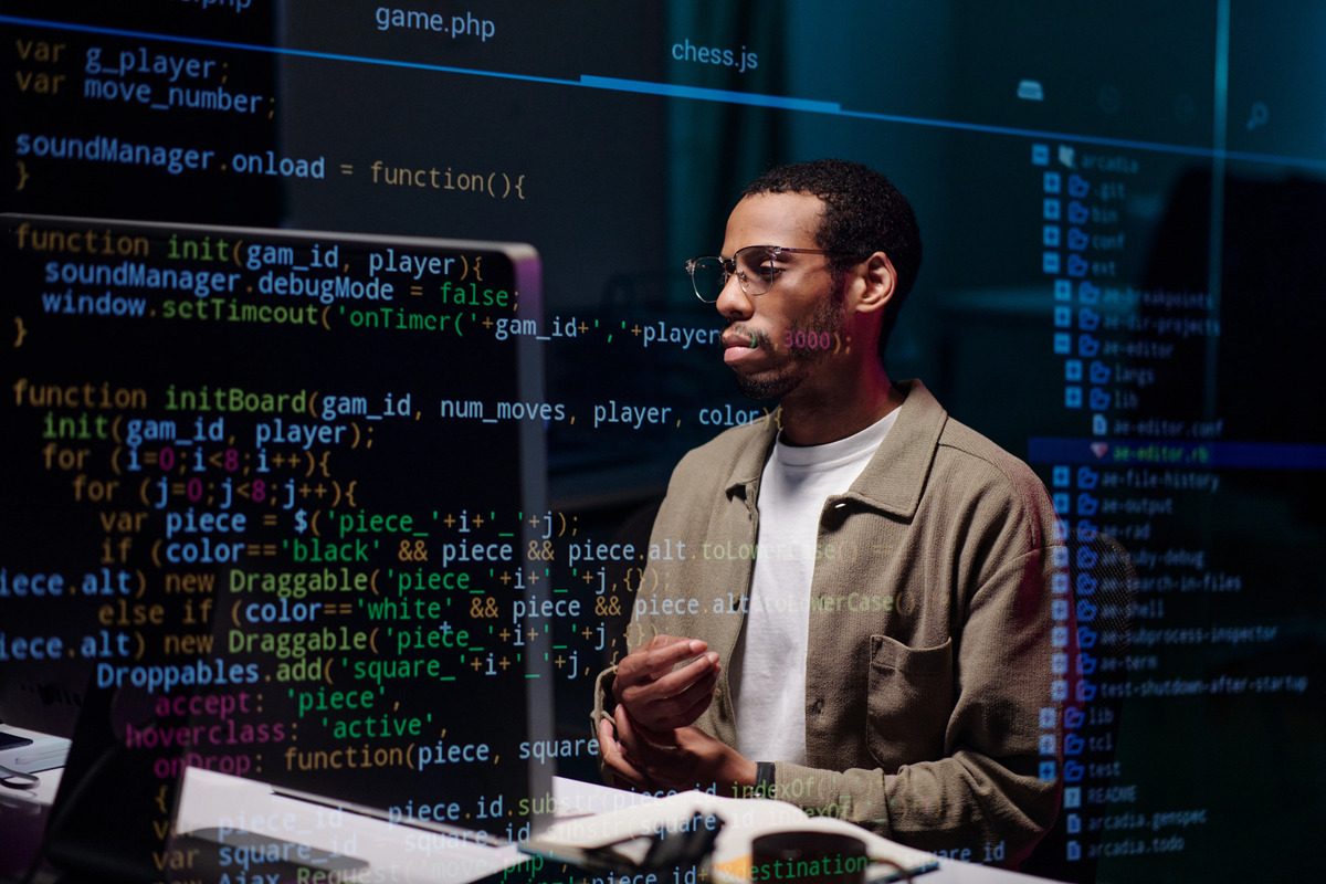 Young person studying programming code on a monitor in a work environment