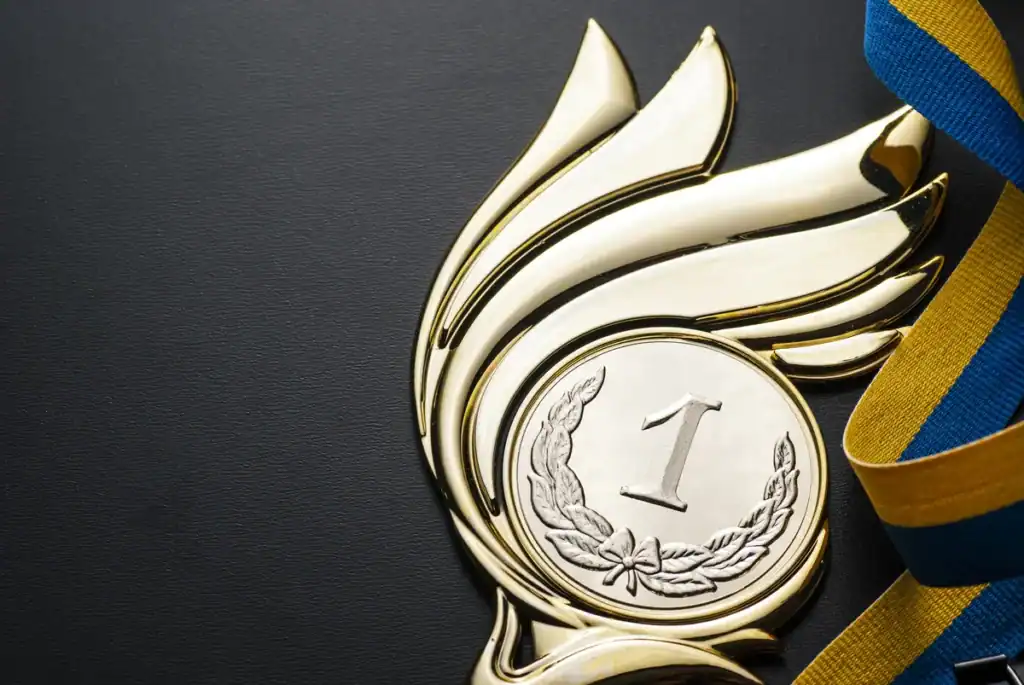 Gold medal of champions with red, white and blue ribbon turned for the winner of a competition