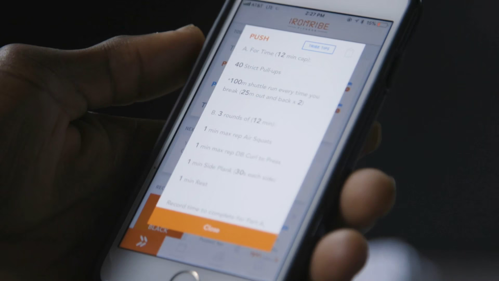 close-up of a phone with an “iron tribe's” application being displayed