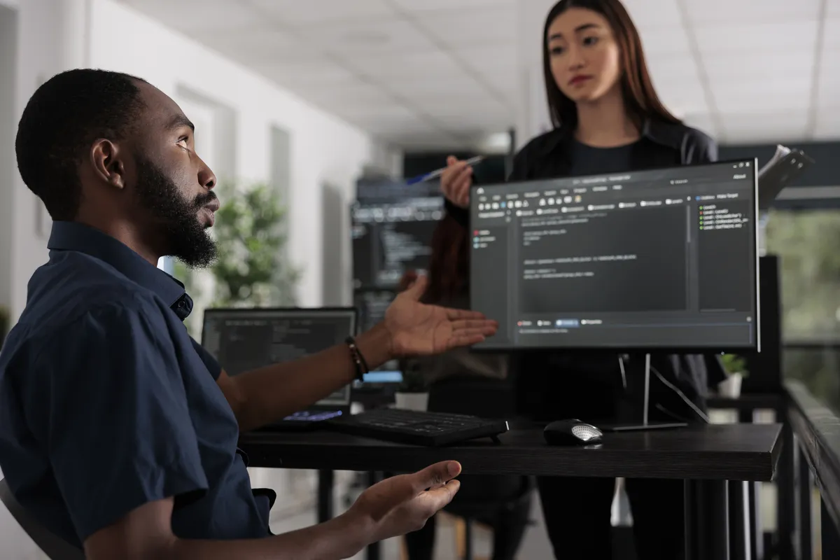 Systems engineer programming the user interface in a busy development agency