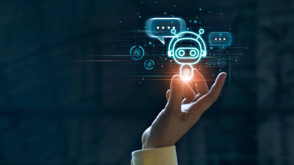 Photo of a hand holding up a graphic of a robot with chat bubbles