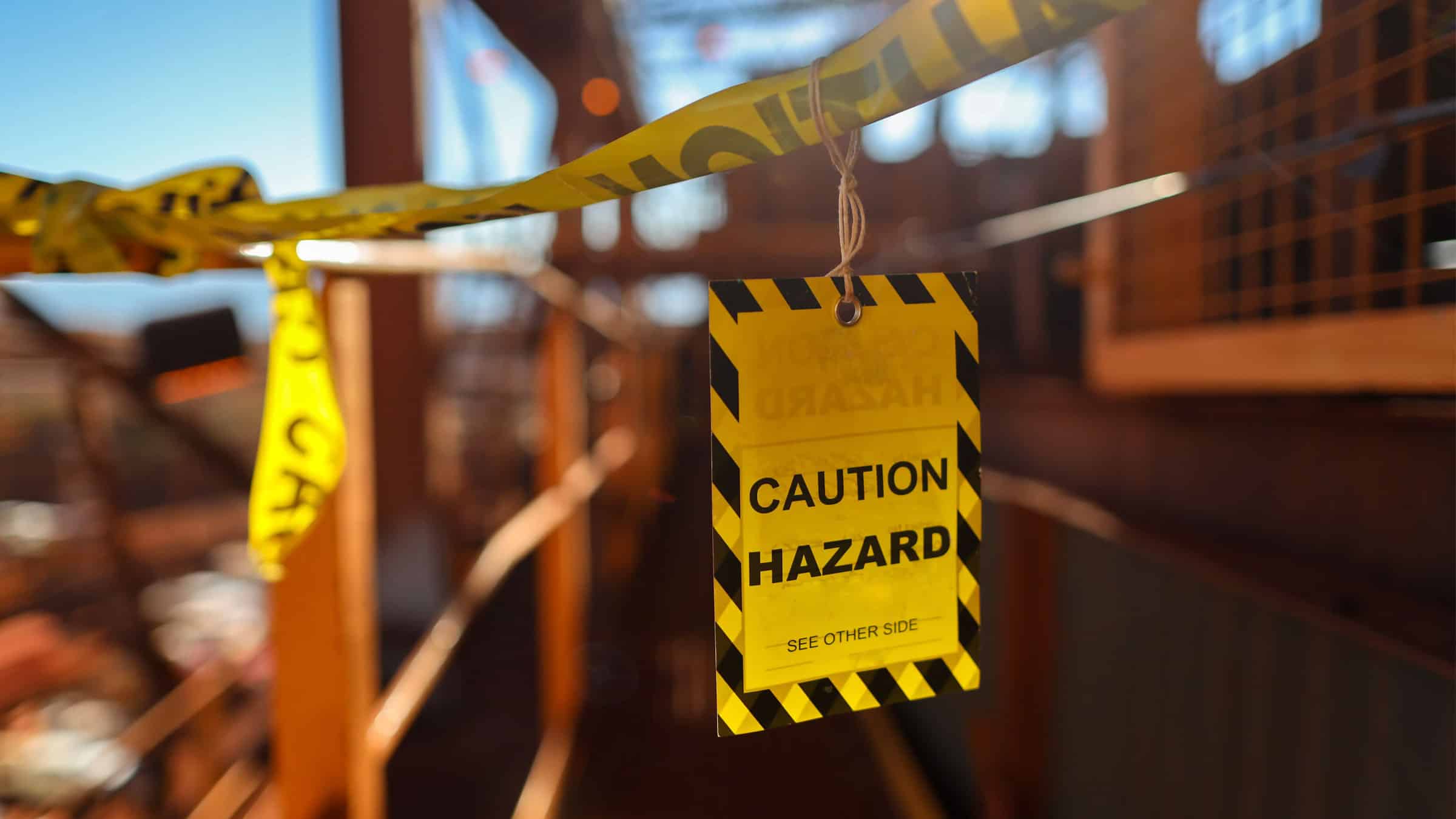 Photo of caution tape with a Caution Hazard tag