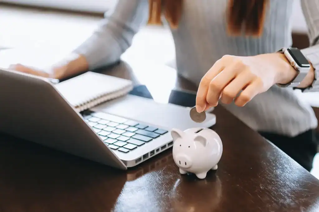 woman putting coins in a piggy bank for a business growing for profit and saving money for the future