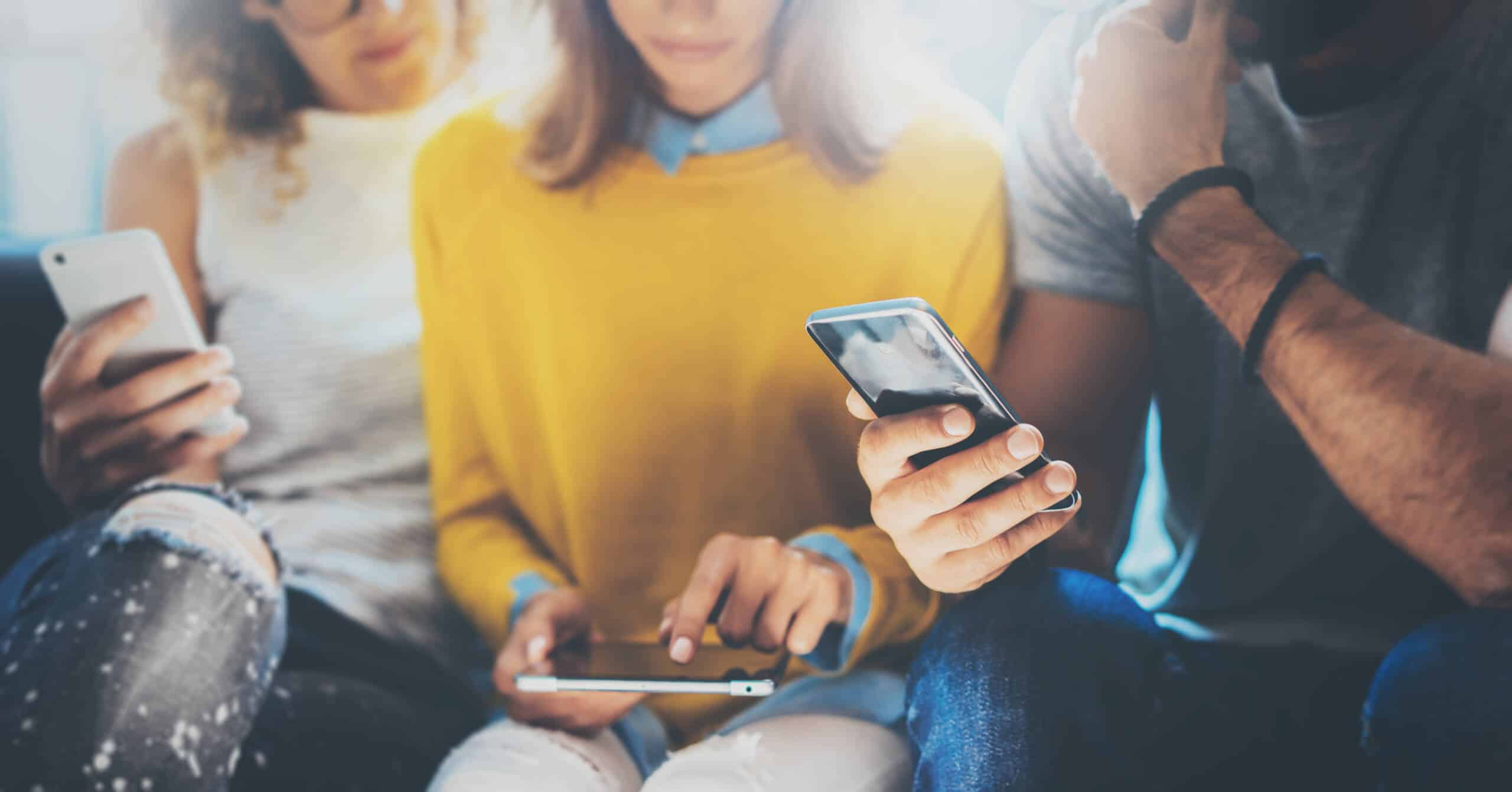 Group of people using smartphones and tablets, illustrating best practices for mobile UX design and user engagement