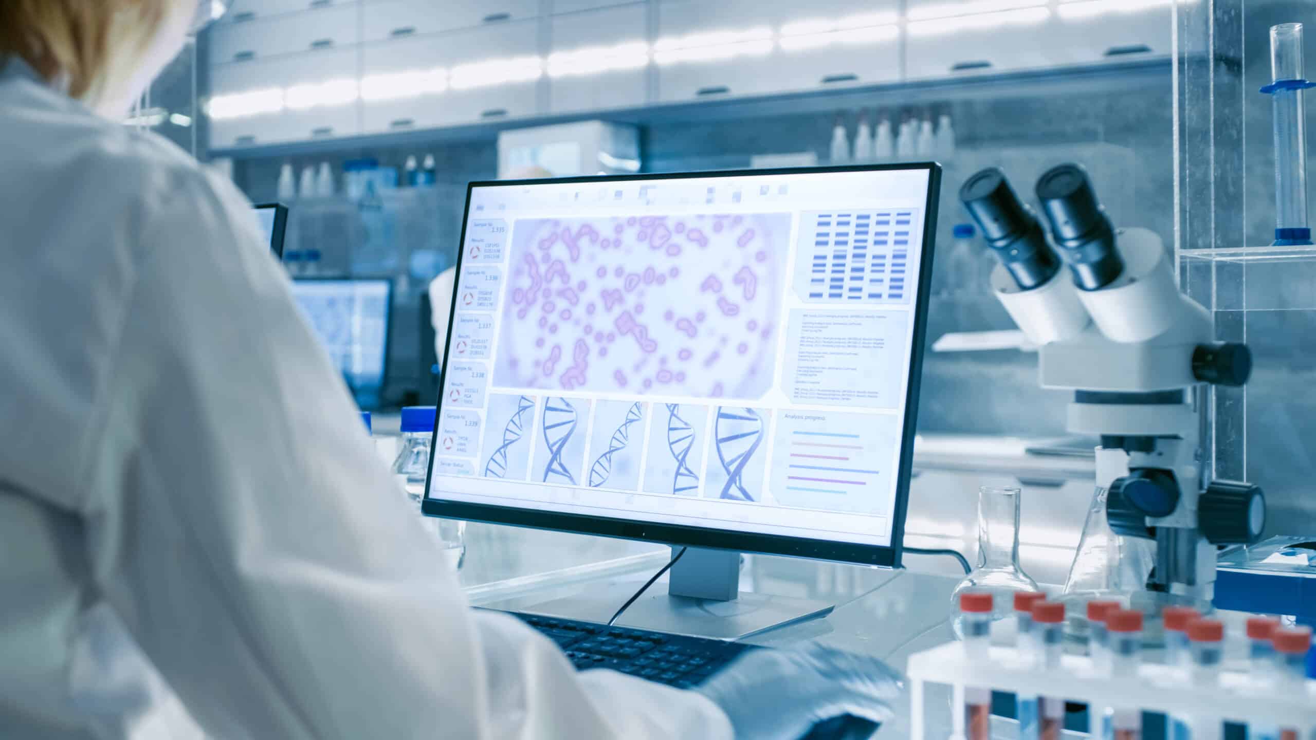 Scientist analyzing medical data on a computer screen in a high-tech laboratory, illustrating user-centered design in healthcare UX.