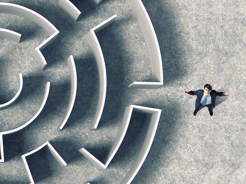 Overcoming UX challenges: Business professional navigating a complex maze representing UX strategy and design solutions.