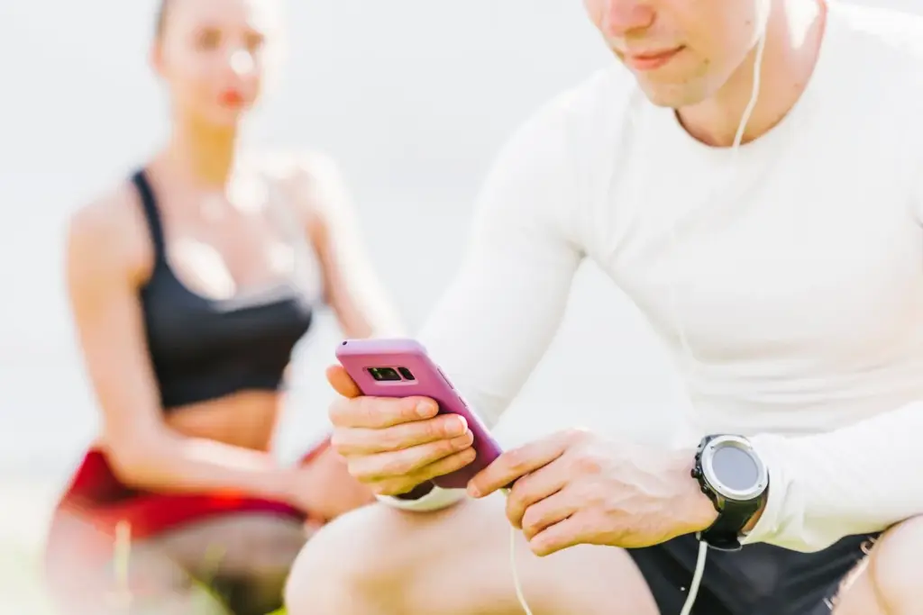 A person checks their mobile phone, representing a user monitoring vitals on the Medaxion mobile platform developed by unosquare.